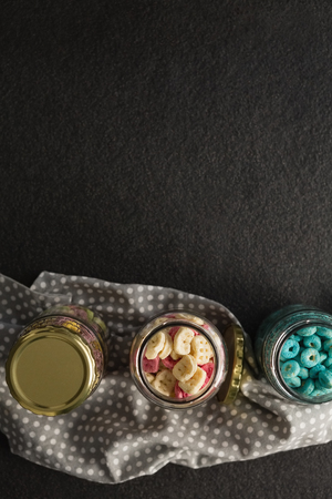 Three jars with various breakfast on black backgroundの写真素材