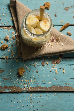 Fruit cereal in jar with napkin cloth on a wooden tableの写真素材