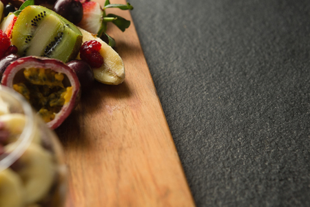 Various fruits on chopping board on black backgroundの写真素材