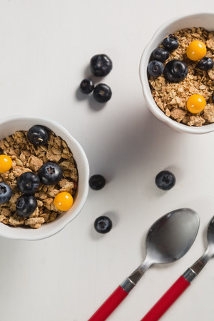 Overhead of blueberry, golden berry and oatmeal in bowlの写真素材