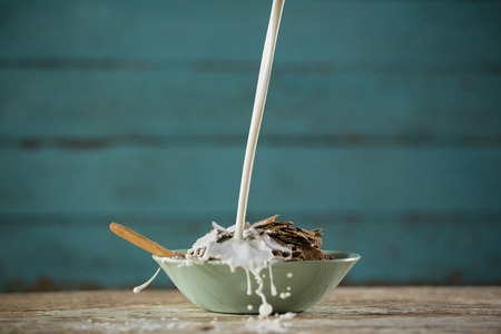 Close-up of milk being poured in wheat flakesの写真素材
