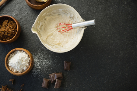 Directly above shot of batter in bowl by ingredients on table