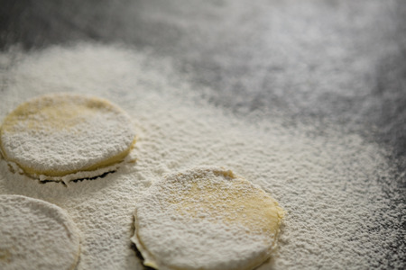 Close up of flour on unbaked cookies on tableの写真素材