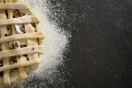 Close up of apple pie amidst flour on tableの写真素材