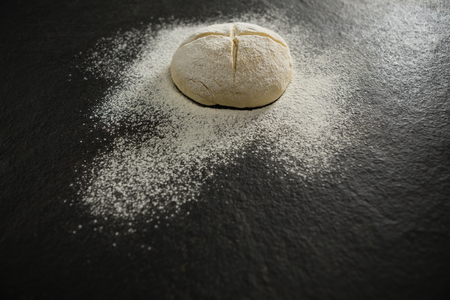 High angle view of flour on unbaked bun on tableの写真素材