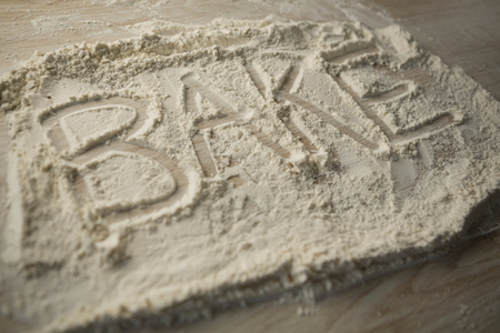 High angle view of bake text on flour at wooden tableの写真素材