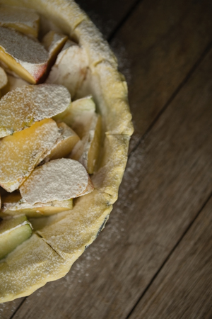 Close up of apple slices on pastry dough in baking pan on wooden tableの写真素材