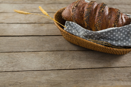 High angle view of brown bread in basket on wooden tableの写真素材