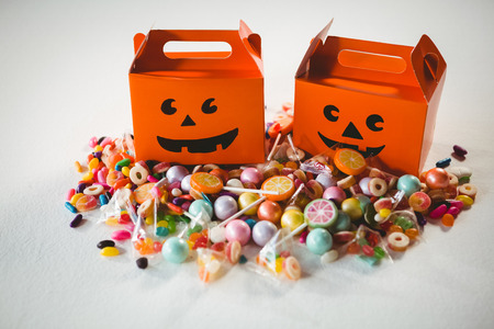 Orange boxes by various sweet food over white background