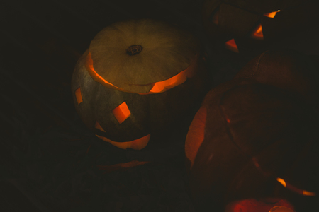 High angle view Illuminated jack o lanterns in darkroomの写真素材
