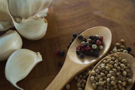Close-up of garlic bulbs and spices on wooden boardの写真素材