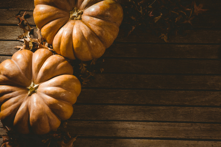 High angle view of orange pumpkins with autumn leaves on tableの写真素材
