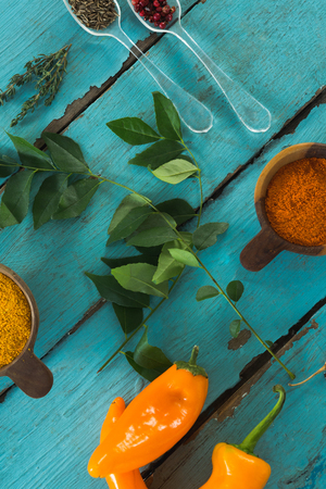 Overhead view of various spices and herbs on wooden tableの写真素材