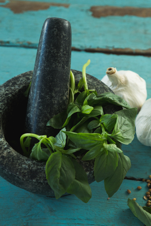 Close-up of mortar and pestle with herbs and spices on wooden tableの写真素材