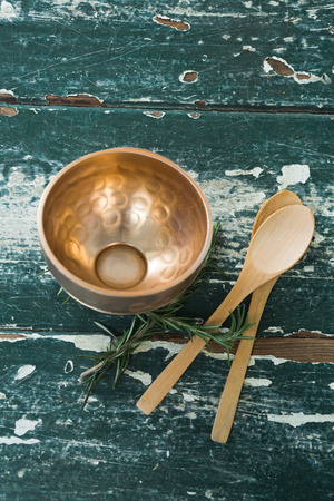 Overhead of golden steel bowl, spatula and spoon on tableの写真素材