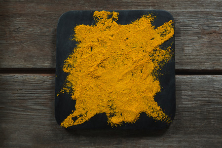 Overhead of turmeric powder on boardの写真素材