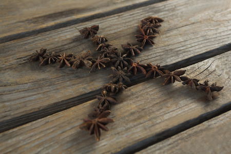 Star anises arranged in star shape on wooden tableの写真素材
