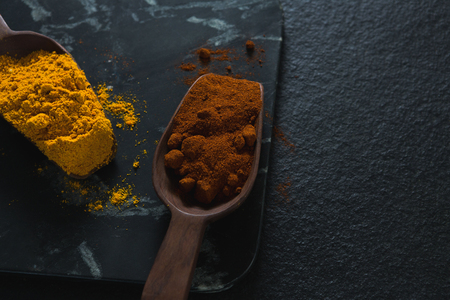 Close-up of turmeric powder and chili powder on wooden spoonの写真素材