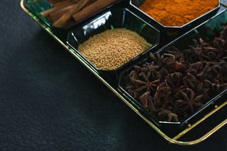 Close-up of anise and cinnamon with spices powder in trayの写真素材