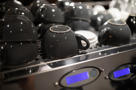 Close-up of coffee cups on coffee machineの写真素材
