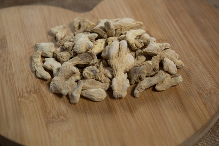 Close up of dried gingers on wooden serving boardの写真素材
