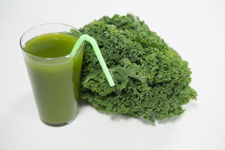 Close up of fresh kale and juice on white backgroundの写真素材
