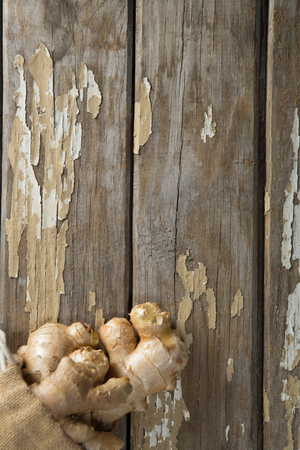 Overhead view of fresh gingers in burlap sack on weathered wooden tableの写真素材
