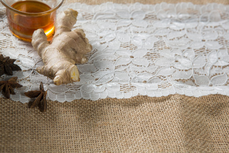 Close-up of ginger with star anise and tea cup on burlap