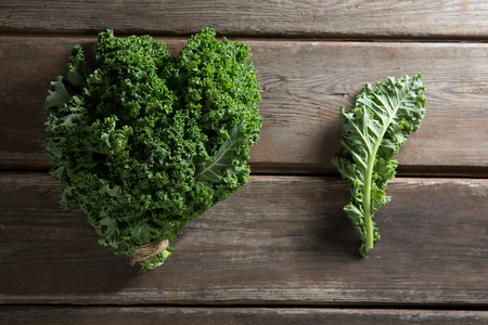 Overhead view of fresh kale vegetable on wooden tableの写真素材