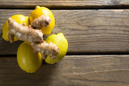 Overhead view of lemons with ginger on wooden tableの写真素材