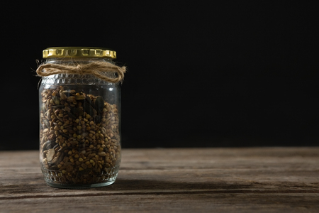 Glass jar of homemade granola and muesli on wooden tableの写真素材