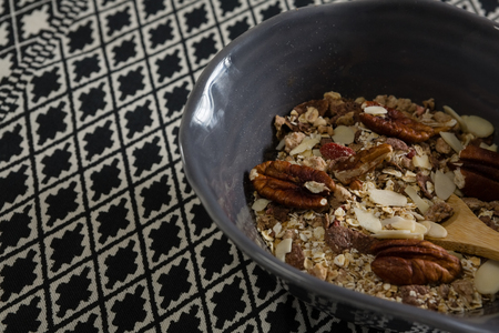 Bowl of breakfast cereals with spoon on table clothの写真素材