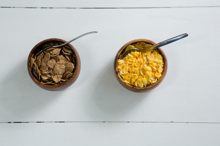 Wheat flakes and wheaties cereal in bowl on white background