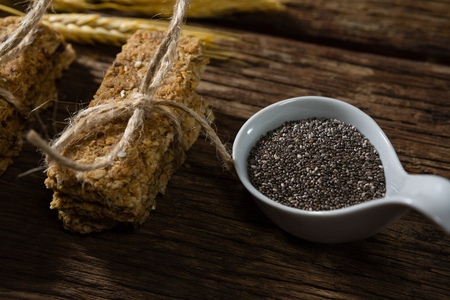 Close-up of granola bars tied with string and grains on spoonの写真素材