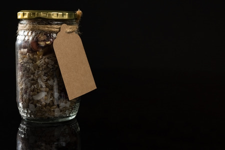 Dried fruit mix in a glass jar on black backgroundの写真素材