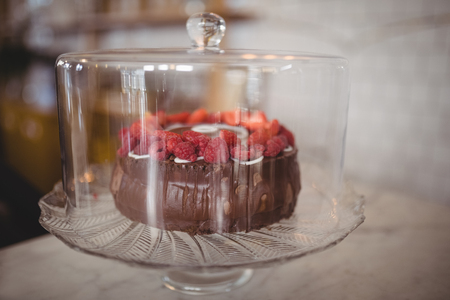 Close up of fresh raspberry cake in glass container on table at coffee shopの写真素材