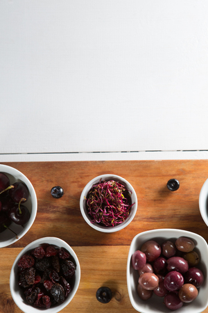 Beetroot slice with various fruits in bowls on cutting board over tableの写真素材