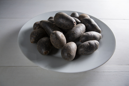 Sweet potatoes in plate on white tableの写真素材