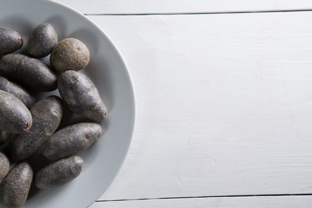 Overhead view of sweet potatoes in plate on white tableの写真素材