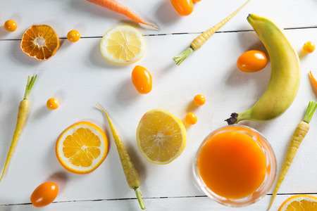 Overhead view of various fruits with juice on tableの写真素材