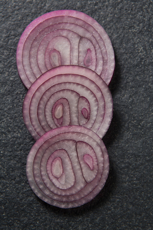Close-up of onions arranged on gray slateの写真素材