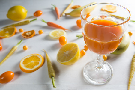 Close-up of orange juice glass with fruits on table