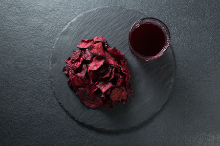 Overhead view of beetroot with juice on plate over slateの写真素材