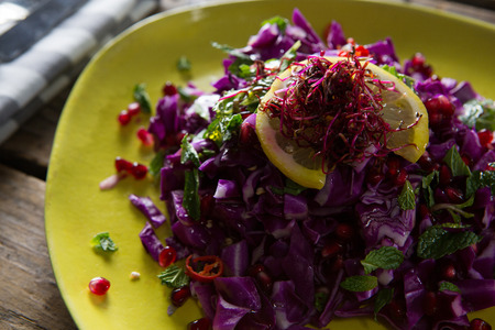 Close-up of salad in plate on wooden tableの写真素材
