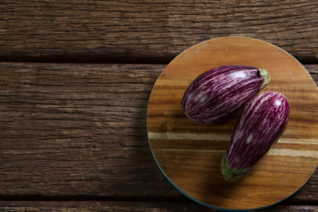 Overhead of two eggplant on chopping boardの写真素材
