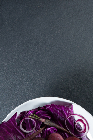 Overhead view of various vegetables in plate on gray slateの写真素材