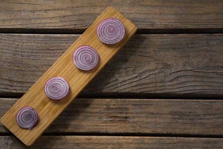 Overhead view of sliced onions on a wooden trayの写真素材