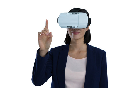 Businesswoman gesturing while using virtual reality headset against white background