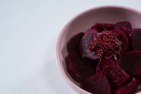 Close-up of slices of beetroots in a bowl on white backgroundの写真素材
