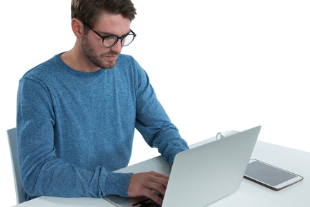 Man using laptop at desk against white background